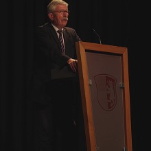 Sarrazin im Bürgersaal - vor ihm das Wappen der Gemeinde Betzigau