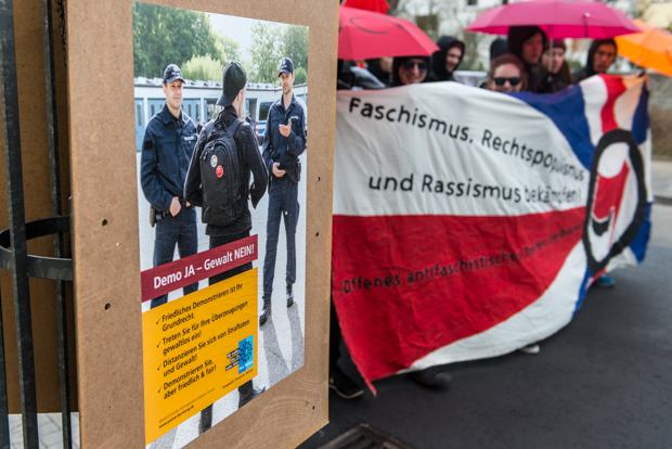 Plakat der Polizei vor einem Transparent der Gegendemonstranten beim "Tag der Heimattreue" am 19.03.2016 in Bruchsal | © Christian Martischius